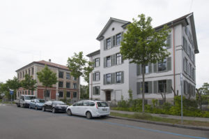 Schulhaus mit Fensterladen und Sprossenfenster