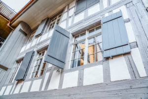 sprossenfenster-mit-grauen-fensterlaeden